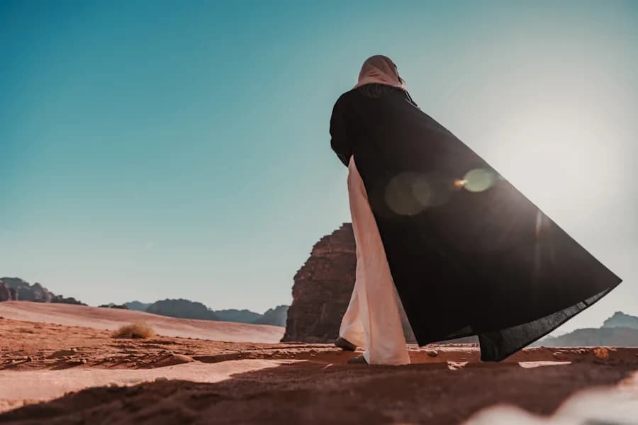 A woman in a black dress standing in the desert